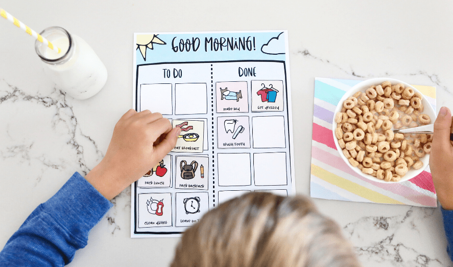 boy eating breakfast looking at morning routine chart